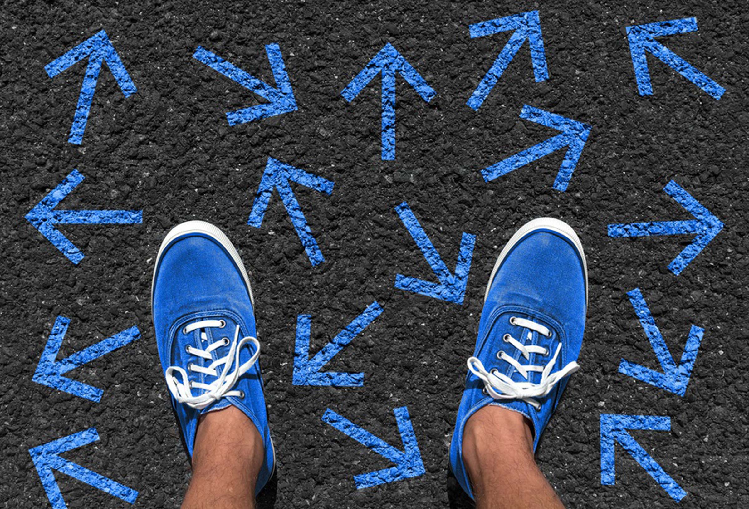 Blaue Schuhe folgen stehen auf vielen kleinen Blauen Pfeile - Projekt JobGo - Orientierung nach der Schule