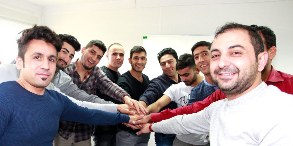 Eine Gruppe ausländische Teilnehmer streckt die Hände in der Mitte zusammen