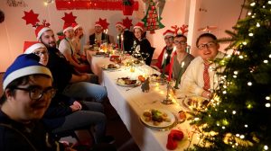 bbw-Teilnehmende sitzen am Tisch und feiern gemeinsam Weihnachten